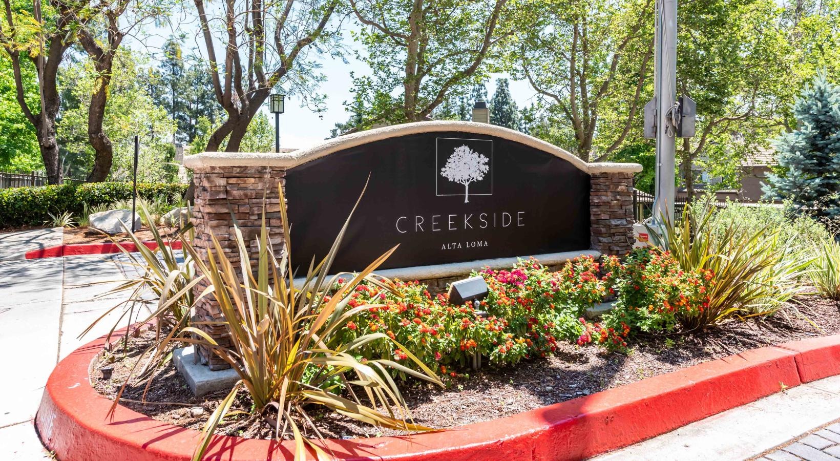 Find your perfect fit at Creekside Alta Loma property sign with flowers